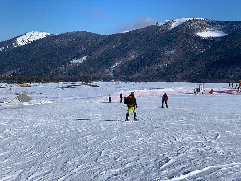 Pessoas esquiam em pista em dia de céu azul no sul do Chile