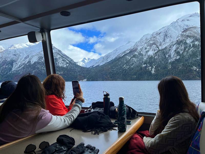 Turistas observam paisagem nevada a partir de barco que faz passeio a Puerto Blest