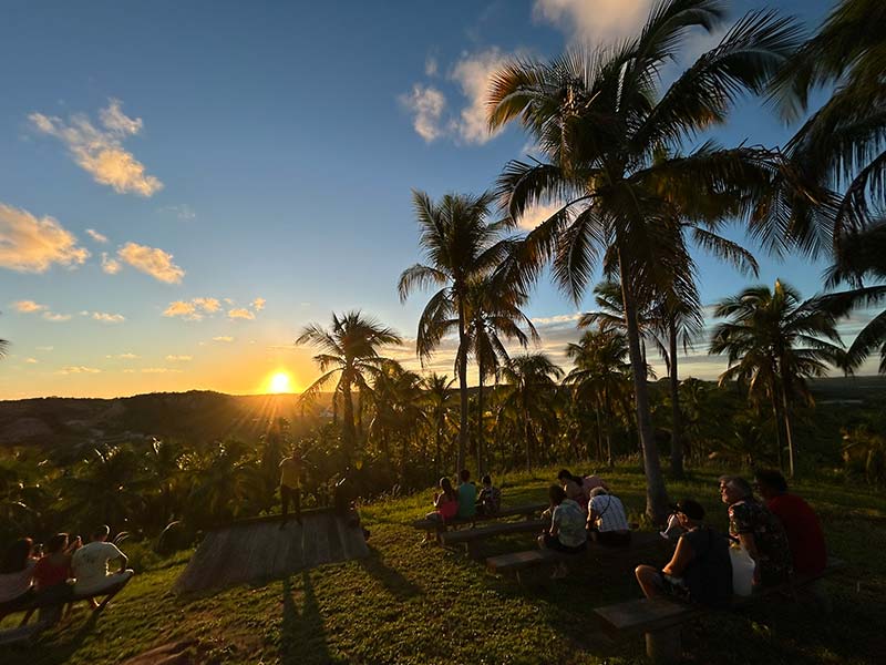 Pessoas acompanham o pôr do sol no Paraíso Sunset, em Japaratinga