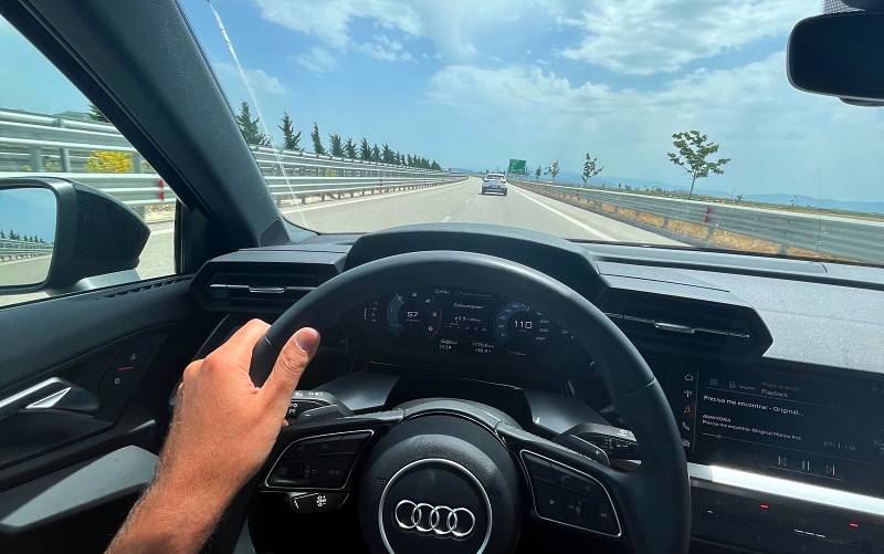 Homem segura volante de um Audi em estrada perto de Tirana