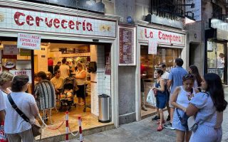 Fachada da Cerveceria La Campana com fila na porta, ótimo local pra comer tapas em Madrid