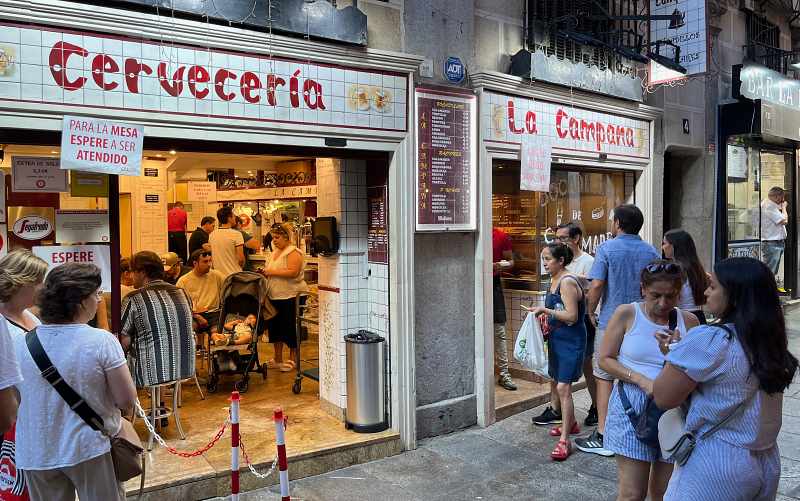 Fachada da Cervecería La Campana com fila na porta, ótimo local pra comer tapas em Madrid