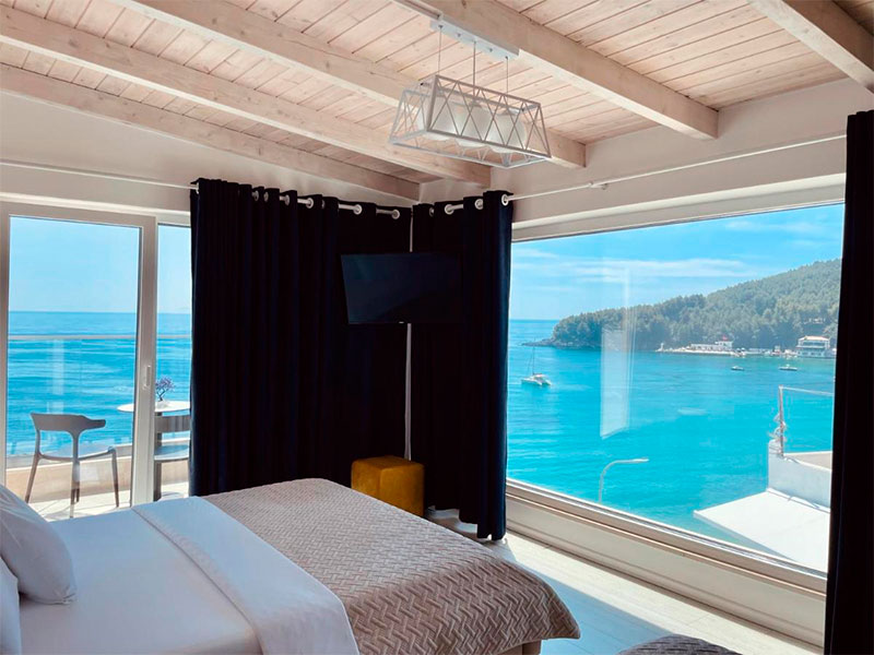 Quarto do Ionian com cama de casal, varanda e grande janela com vista para o mar