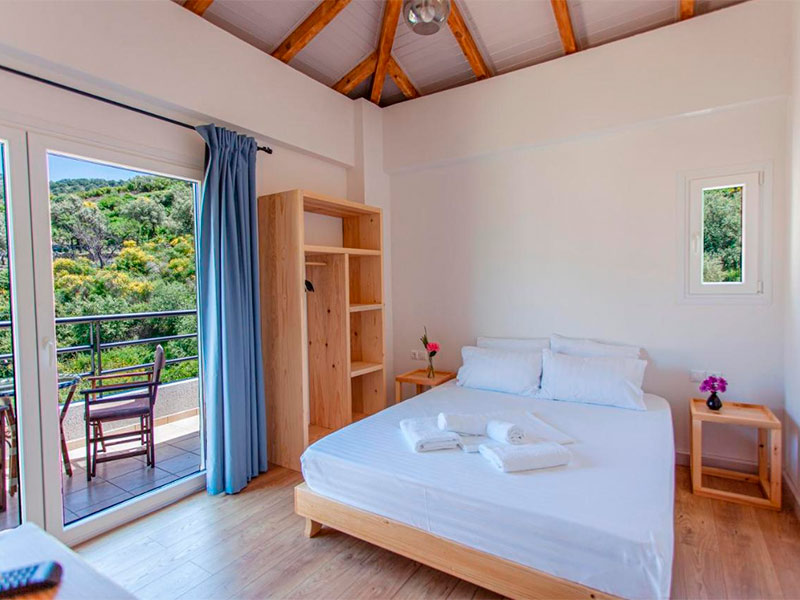 Quarto do Toni Hotel, dica de onde ficar em Himara, com cama de casal e varanda com vista para o verde