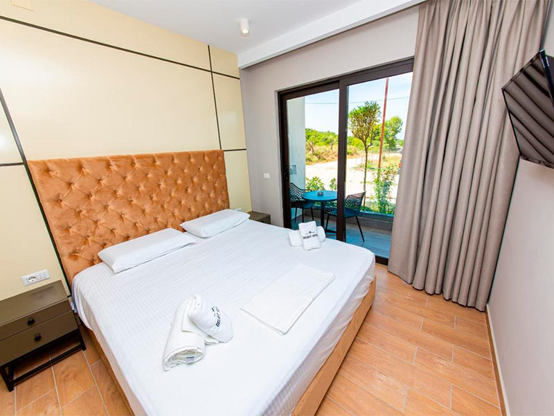 Cama de casal com varanda e cortina do Delight, dica de hotel em Ksamil