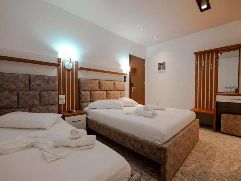 Quarto do Hotel Meta com duas camas de casal com toalhas em cima delas