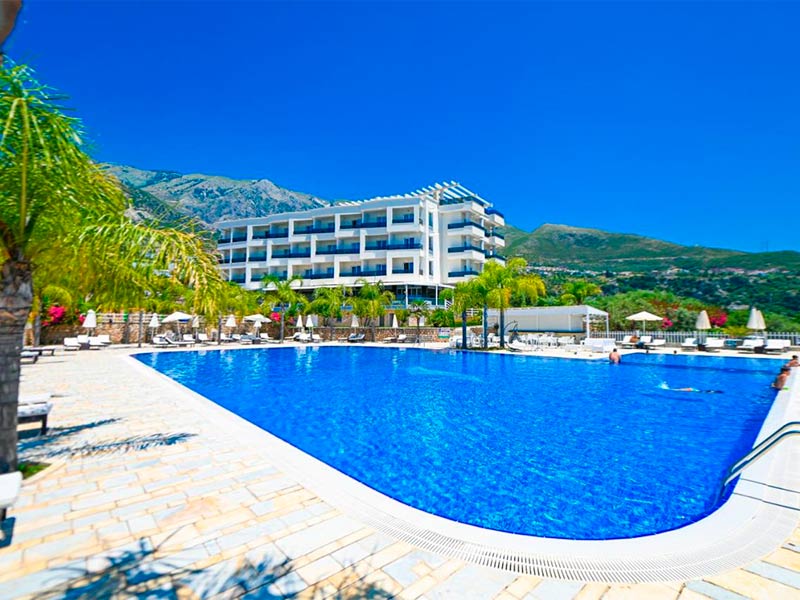 Piscina do Elysium com espreguiçadeiras e guarda-sóis em dia de céu azul