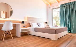 Quarto do First House, dica de onde ficar na Albânia, com cama de casal, cortina verde e piso de madeira