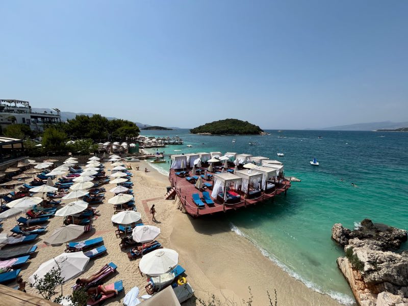 Lounges no mar esverdeado de Ksamil em dia de céu azul