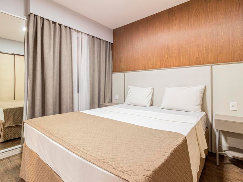 Quarto do H4 Fortune Jardins com cama de casal e janela com cortinas