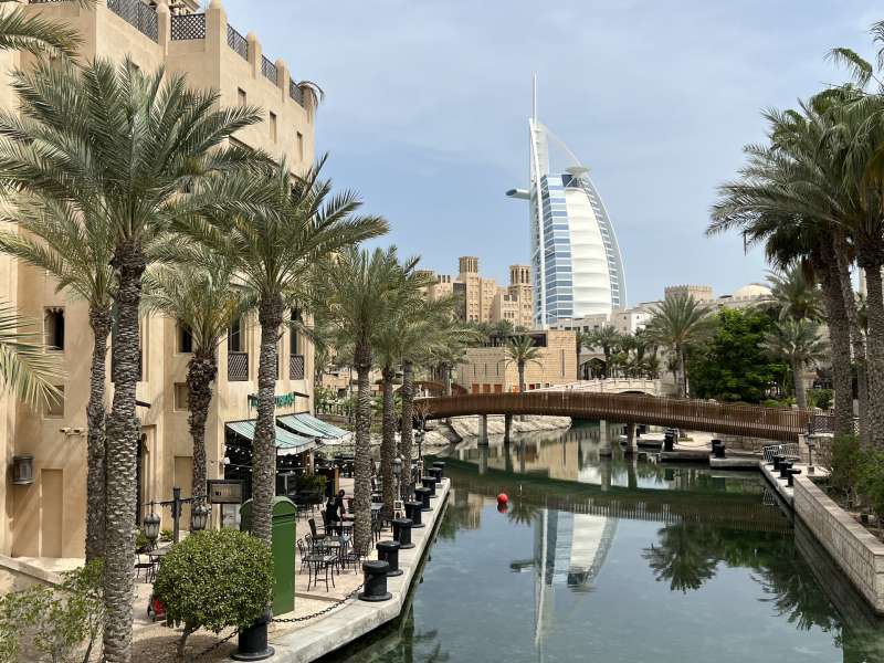 Burj Al Arab em meio a jardim com coqueiros e lago