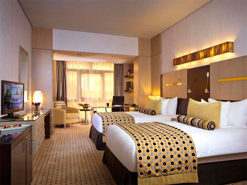 Quarto do Time Grand Plaza Hotel com duas camas, carpete e TV