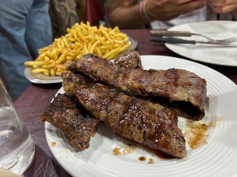 Dois pedaços de carne entraña com batatas fritas no La Entrañita, dica entre os restaurantes baratos em Buenos Aires