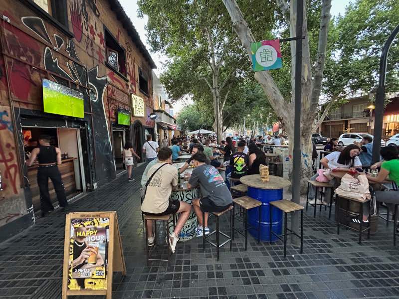 Jovens sentados em um bar na Av. Arístides Villanueva, dica de o que fazer à noite em Mendoza