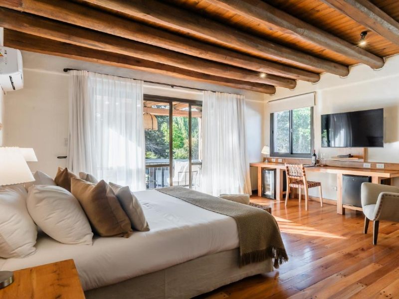 Quarto do Lares de Chacras com cama de casal, piso de madeira e TV