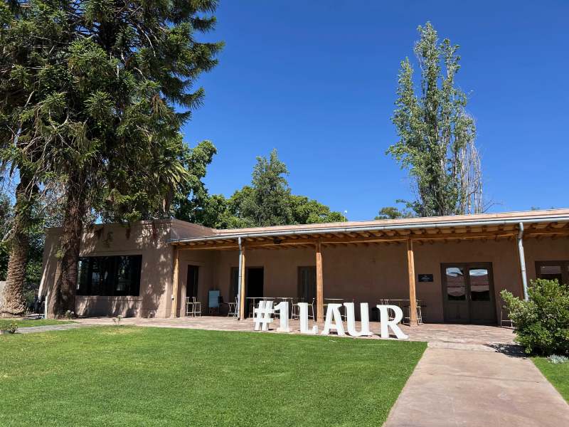 Entrada da olivícola Laur, dica de o que fazer em Mendoza, em dia de céu azul