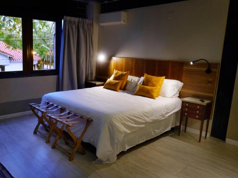 Quarto do 718 Rufino Petit Hotel, dica de onde ficar em Mendoza, com cama de casal e piso de madeira