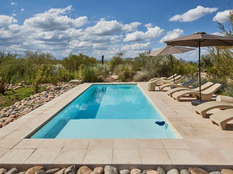 Piscina ao ar livre vazia da Casa de Huéspedes Bodega Gimenez Riili em dia de céu azul com nuvens