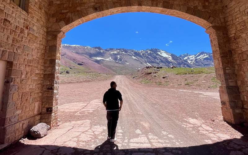 Homem caminha saindo de túnel nos Andes na fronteira entre Argentina e Chile