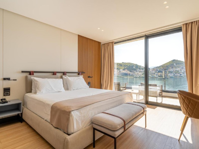 Quarto do Yacht Premium Hotel, dica de onde ficar em Saranda, com cama de casal e varanda com vista para o mar